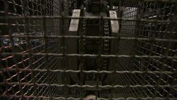 Machinery operates behind a wire cage in a sausage making plant. Stock Footage