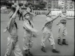 Young boys in uniform march past Egyptian Colonel Gamal Abdel Nasser and Egyptian General Mohammed Naguib who salute from review stands. News Clip