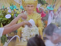 CU Shot of Men and women taking water and pouring it over Buddha statue in front of temples (seen from front) / Yangon, Yangon Division, Myanmar  Stock Footage