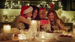 Playful friends in santa hats and reindeer antlers taking selfie at candlelight Christmas table Stock Footage