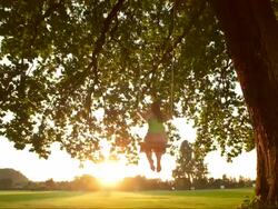 HD DOLLY SLOW MOTION: Woman Swinging At Sunset Stock Footage