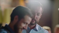 Restaurant owner speaks with bartender and greets customers at bar Stock Footage