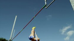 Female pole vaulter jumps and clears bar before pole knocks bar off Stock Footage