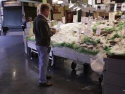 Man looks at seafood display at Pike Place Market Stock Footage