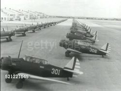 MOT 1939: TEXAS: US ARMY AIR CORPS TRAINING CENTER: RANDOLPH AIR BASE: **HA LS Two rows of Vultee BT-13B 'Valiant' basic trainer aircraft on field, pilots in training, first aircraft (#301) taxiing out of single line, turning left, others in line Instructional Video