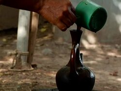 Ethiopian woman pouring coffee into pot Stock Footage
