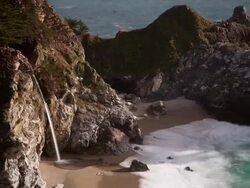 WS T/L Water falling off cliff onto beach / Big Sur, California, United States Stock Footage