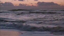 Ocean waves roll on to a beach. Stock Footage