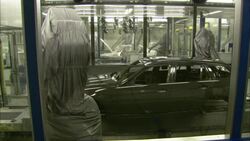 Robotic arms open the doors and the trunk of a car shell on an assembly line in an automobile factory. Stock Footage