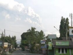 Merapi volcano erupts at dawn visible from northern suburb of Yogjakarta city; Indonesia. 7 November 2010 / AUDIO Stock Footage