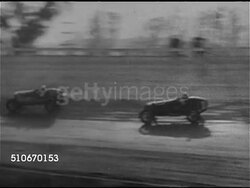 1920s: AUTO RACING: HA WS Racecars on curve, WS Cars racing on straightaway passing stopped car w/ one car clipping, spinning car knocking driver out onto track. WS Racecar flipping, catching fire. WS Two cars rounding corner, others on dusty track. Instructional Video