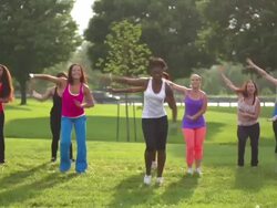 Diverse women wearing colorful clothing doing Zumba in suburban park Stock Footage