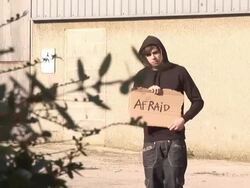 Hoody holding board saying &quot;AFRAID&quot; - HD &amp; PAL Stock Footage