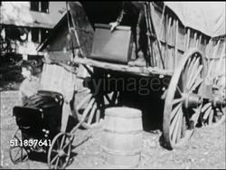 MOT: EARLY AMERICANA: WESTWARD EXPANSION REENACTMENT: Young girl, daughter pulling doll carriage up to wagon, male, father placing into Conestoga covered wagon. Instructional Video
