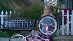MS Young girl fixing her bicycle by herself Stock Footage