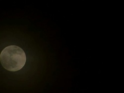 Low Angle static _ Clouds drift past a full moon Stock Footage