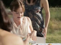 Young woman handing food to friends at outdoor dinner party Stock Footage