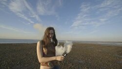 Woman dancing on beach with smoke bomb Stock Footage