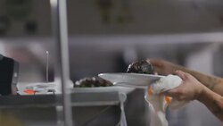 Restaurant chef places finished steak plates on counter, rings bell, and spikes ticket in kitchen Stock Footage