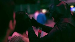 young woman receives a rose from a Batman impersonator and poses for photos in downtown Vegas Stock Footage