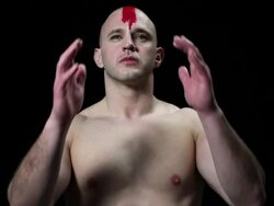 Man with red cross painted on his head, head in hands Stock Footage
