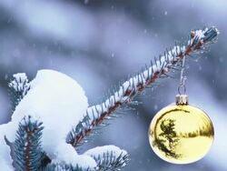 Snow gently falling on Christmas ornament hanging from tree Stock Footage