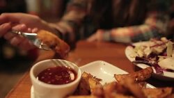 Young woman eating french fries in the pub. Stock Footage