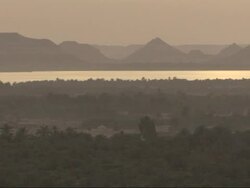 A silhouetted pyramid is seen on a hazy riverbank. Stock Footage