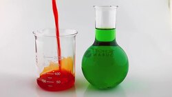 Pouring orange liquid into Beaker Stock Footage