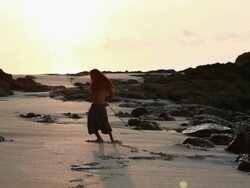 MS Rasta man spinning poi balls behind his back on beach with sunrise / Montezuma, Punteranes, Costa Rica Stock Footage