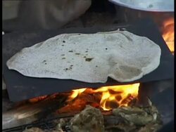 CU flatbread cooked over open fire, hand turns it over, Egypt Stock Footage