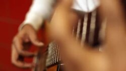 Street musician skillfully finger picks acoustic guitar in urban subway station Stock Footage