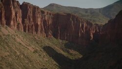 Canyon walls cast shadows into a grassy gorge. Stock Footage