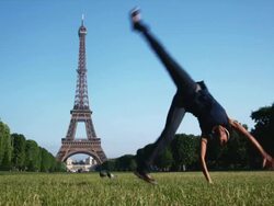 woman doing a cartwheel in front of the Eiffel tower Stock Footage