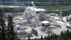 Pan up to cement plant next to a river Stock Footage