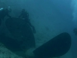 F/S underwater,recreational  divers in the giant propeller of a wreck Stock Footage