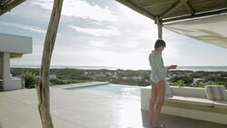Woman photographing view on luxury patio overlooking ocean Stock Footage