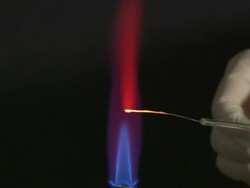A flame test used in chemistry to detect the presence of certain metal ions, based on each elements characteristic emission spectrum (Strontium Carbonate) Stock Footage