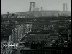 1948: NEW YORK CITY: HA WS East side of New York City w/ elevated subway train tracks & bridge BG. Immigrant boy & girl in home playing musical instruments bandurria or mandolin & violin. Immigrant family having dinner at round table in home. Instructional Video