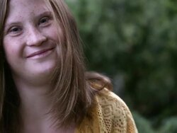 Slow motion rack focus of girl with down syndrome smiling. Stock Footage