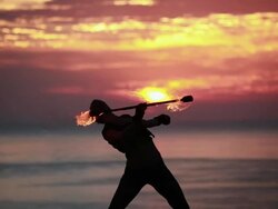MS TU Female poi dancer perfoming with firestick in front of fiery sunrise sky / Montezuma, Costa Rica Stock Footage