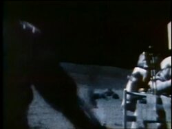 1972 astronaut passing camera with another in background on Moon / Apollo 16 Stock Footage