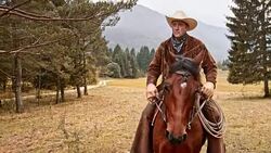 SLO MO Rancher riding his horse across meadow Stock Footage