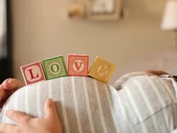 A pregnant women using blocks to spell the word LOVE on her stomach. Stock Footage