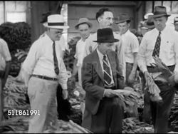 1942: TOBACCO AUCTION: MS Auctioneer walking row followed by buyers. HA WS People walking between rows of cured tobacco.  WWII, World War II, Home Front, agriculture, cigarettes. Instructional Video