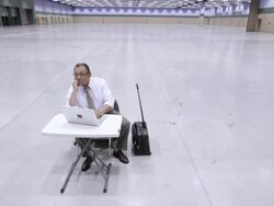  WS Businessman sitting at small table in large empty conference facility, looking around room, and working on laptop computer / Seattle, Washington, United States Stock Footage