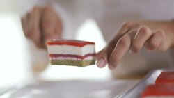 Pastry chef's hands  lift cake from tray and place on dessert dish Stock Footage