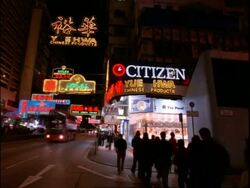 Establishment signs and people at night in Nathan Road, Tsim Sha Tsui tourist district, Kowloon, Hong Kong Stock Footage