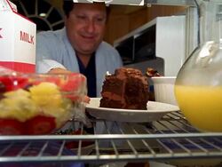 Refrigerator point of view man opening door and lifting piece of chocolate cake, but taking bowl of fruit Stock Footage