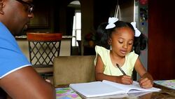 MS Smiling young girl in discussion with father while drawing in notebook at dining room table Stock Footage